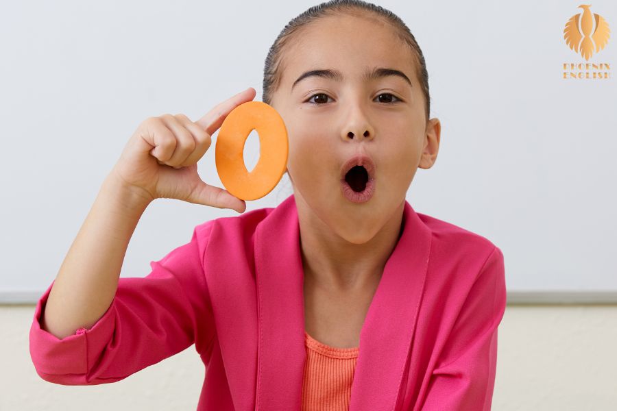 A teenage girl holding an O shape in her hands and pronouncing it